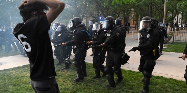 Aurora police officers charge towards Elijah McClain protesters at the Aurora Police department's headquarters at the Aurora Municipal Center June 27, 2020. (Photo by Andy Cross/MediaNews Group/The Denver Post via Getty Images)