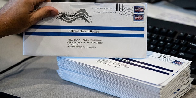 FILE - In this May 28, 2020, file photo, Dave Turnier processes mail-in ballots at at the Chester County Voter Services office in West Chester, Pa., prior to the primary election. The civic ritual of casting a ballot has been disrupted by a global pandemic and dramatically animated by social unrest. And If the results of a frustrating, chaotic primary in Georgia are a measure, the notion of democracy itself will also be on the ballot in the November election. Congress is now considering sending $3.6 billion to states to help facilitate safe and fair elections as part of another round of relief funds to recover from the coronavirus pandemic. (AP Photo/Matt Rourke, File)