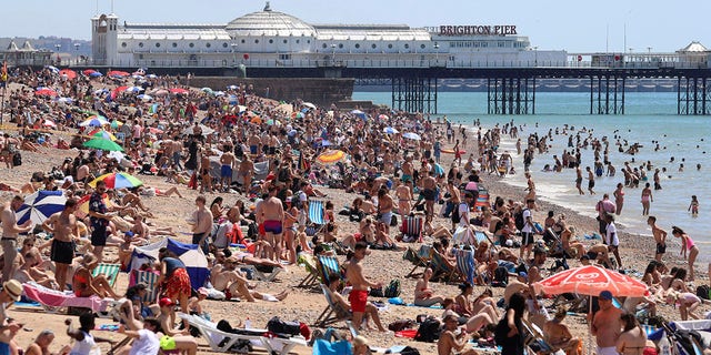 Crowds gather at the beach in Brighton, England, on Thursday. (Gareth Fuller/PA via AP)