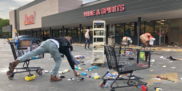 People clean up items outside a Jewel grocery store Monday in Chicago, after the business was broken into during unrest in reaction to the death of George Floyd. (AP)