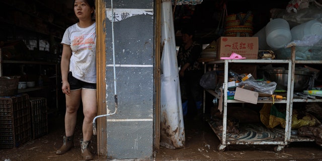 In this photo released by Xinhua News Agency a resident looks out from her flood damaged home in Bifeng Town of Zheng'an County in Zunyi, southwest China's Guizhou Province June 13.