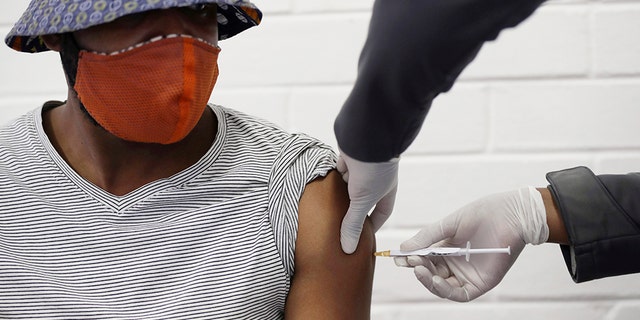 FILE - In this Wednesday, June 24, 2020 file photo, a volunteer receives a COVID-19 test vaccine injection developed at the University of Oxford in Britain, at the Chris Hani Baragwanath hospital in Soweto, Johannesburg, South Africa. People on six continents are testing experimental shots as the race for a COVID-19 vaccine enters a defining summer, with even bigger studies poised to prove if any leading candidate really works - and possibly offer the public a reality check. (AP Photo/Siphiwe Sibeko)