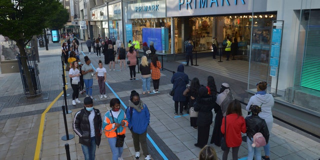 Shoppers queue up outside a Primark store as it reopened in Birmingham, England, on Monday. (AP/PA)