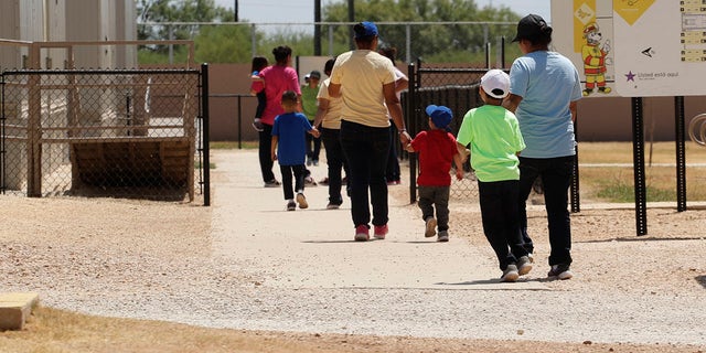 ​​​​​​​Immigrants seeking asylum hold hands as they leave a cafeteria at the ICE South Texas Family Residential Center in Dilley, Texas, Aug. 23, 2019. (Associated Press)