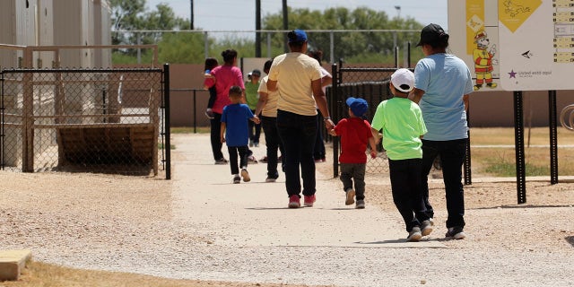 Immigrants seeking asylum hold hands as they leave a cafeteria at the ICE South Texas Family Residential Center in Dilley, Texas, Aug. 23, 2019. (Associated Press)
