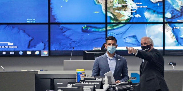 Miami-Dade County Mayor Carlos Gimenez, right, gives a tour to Acting Secretary of Homeland Security, Chad Wolf, of the Miami-Dade Emergency Operations Center, June 8, in Doral, Fla.