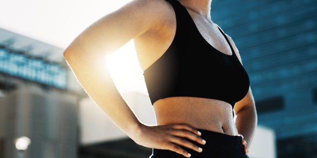 Closeup shot of a sporty woman standing in the city. On Reddit, a user noted that she'd like to be able to "lift weights" and "play and compete" in sports without facing judgment from others.