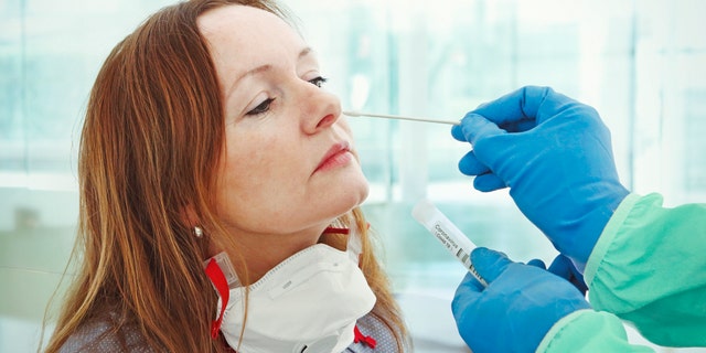 A medic takes a nasal swab from a patient for coronavirus testing. (iStock)