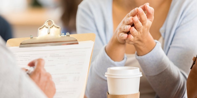 Local store sign on 'triggers' sparks debate on Reddit: 'Nobody's responsibility but your own' 3 Unrecognizable woman has her hands clasped during a job performance review. Her manager is unrecognizable in the foreground taking notes.