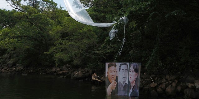 A balloon carrying a banner with images of North Korean leader Kim Jong Un, left, the late leader Kim Il Sung, center, and Kim Yo Jong, the powerful sister of Kim Jong Un, released by Fighters For Free North Korea, is seen in Hongcheon, South Korea, on Tuesday. (Yang Ji-woong/Yonhap via AP)