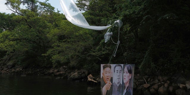 A balloon carrying a banner with images of North Korean leader Kim Jong Un, left, the late leader Kim Il Sung, center, and Kim Yo Jong, the powerful sister of Kim Jong Un, released by Fighters For Free North Korea, is seen in Hongcheon, South Korea, on Tuesday. (Yang Ji-woong/Yonhap via AP)