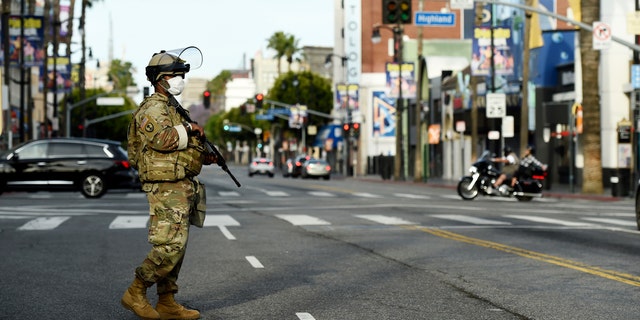 A U.S. National Guard soldier watches over Hollywood Blvd., Sunday, May 31, 2020, in Los Angeles.