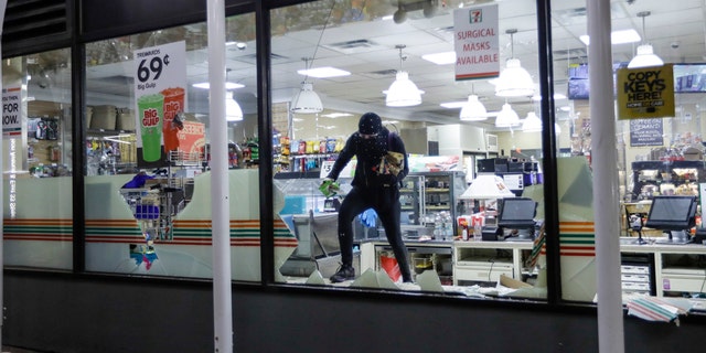 A person carries merchandise from a 7-Eleven store, Monday, June 1, 2020, in New York. (AP Photo/Frank Franklin II)