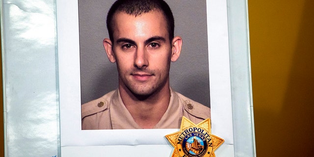 A photo of Las Vegas police officer Shay K. Mikalonis, 29, a four-year veteran of the department, is displayed during a media briefing at police headquarters in Las Vegas on Tuesday, June 2, 2020. Mikalonis was was shot Monday night in Las Vegas. (Steve Marcus/Las Vegas Sun via AP)