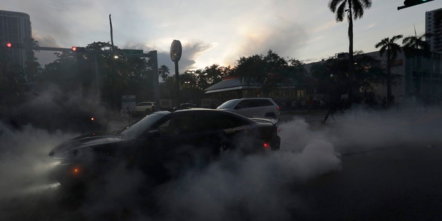 A protester does a burnout as he and others demonstrate over the death of George Floyd, Sunday, May 31, 2020, in Miami.