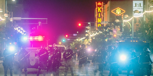 Police in riot gear prepare to clear downtown Albuquerque, N.M., early Monday, June 1, 2020.