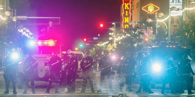 Police in riot gear prepare to clear downtown Albuquerque, N.M., early Monday, June 1, 2020.