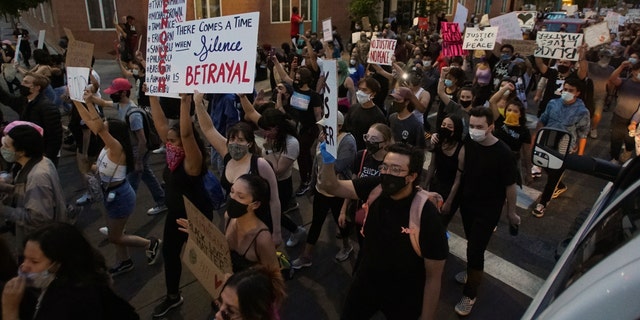 Protesters holding signs block a street Sunday, May 31, 2020, in downtown Albuquerque, N.M.
