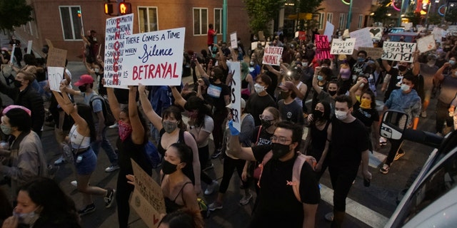 Protesters holding signs block a street Sunday, May 31, 2020, in downtown Albuquerque, N.M.