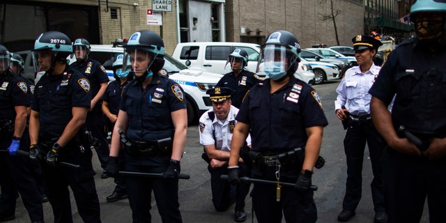 NYPD Deputy Chief McCarthy takes a knee near protesters and other officers as they take part in a march for George Floyd, on June 2, 2020, in New York. (AP Photo/Eduardo Munoz Alvarez)