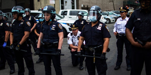 NYPD Deputy Chief McCarthy takes a knee near protesters and other officers as they take part in a march for George Floyd, on June 2, 2020, in New York. (AP Photo/Eduardo Munoz Alvarez)