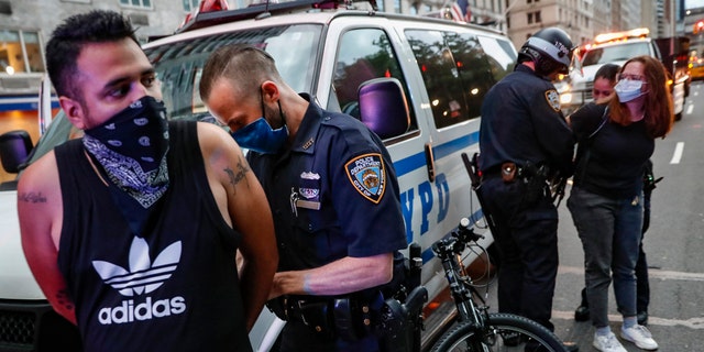 Protesters are arrested by NYPD officers for violating curfew beside the iconic Plaza Hotel on 59th Street, Wednesday, June 3, 2020, in the Manhattan borough of New York. (AP Photo/John Minchillo)