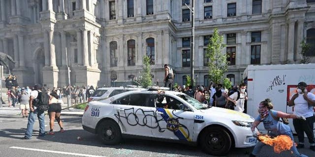 This image from social media contained in court filings appears to show a woman, whom the FBI has identified as Lore Elisabeth Blumenthal, throwing a flaming object at a police cruiser during protests outside City Hall of the death of George Floyd on May 30, 2020.