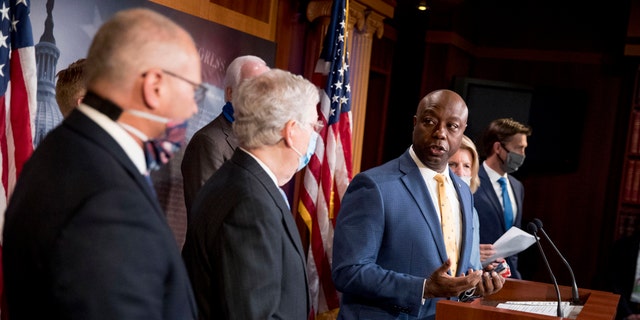 Sen. Tim Scott, R-S.C., accompanied by Senate Majority Leader Mitch McConnell of Ky., second from left, and others, speaks at a news conference to announce a Republican police reform bill on Capitol Hill, Wednesday, June 17, 2020, in Washington. (AP Photo/Andrew Harnik)