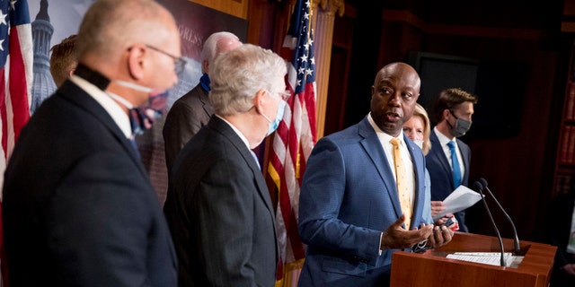 Sen. Tim Scott, R-S.C., accompanied by Senate Majority Leader Mitch McConnell of Ky., second from left, and others, speaks at a news conference to announce a Republican police reform bill on Capitol Hill, Wednesday, June 17, 2020, in Washington. (AP Photo/Andrew Harnik)