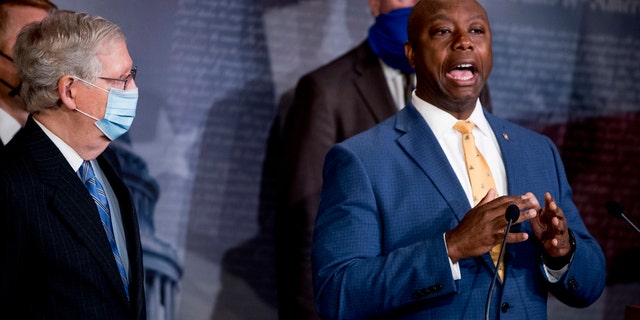 Sen. Tim Scott, R-S.C., right, accompanied by Senate Majority Leader Mitch McConnell of Ky., left, Sen. John Cornyn, R-Texas, center, and others speaks at a news conference to announce a Republican police reform bill on Capitol Hill, Wednesday, June 17, 2020, in Washington. (AP Photo/Andrew Harnik)