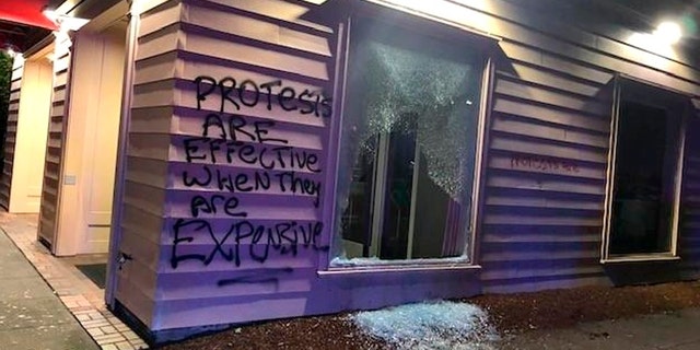 This Friday, June 26, 2020, photo released by the Portland Police Department shows damage after protests calling for an end to racial injustice and accountability for police in Portland, Ore. Some protesters set fire to a police precinct, vandalized businesses and tried to barricade police officers inside their station during a demonstration early Friday morning that ended with law enforcement using tear gas to disperse the crowd, authorities said.<br>