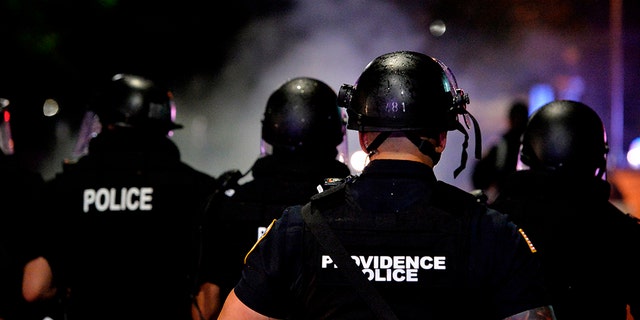 Police officers and National Guard soldiers make their way through a smoke filled street as they chase and confront protesters after curfew and after a peaceful Black Lives Matter rally in Providence, Rhode Island on June 5, 2020. (Photo by Joseph Prezioso / AFP) (Photo by JOSEPH PREZIOSO/AFP via Getty Images)