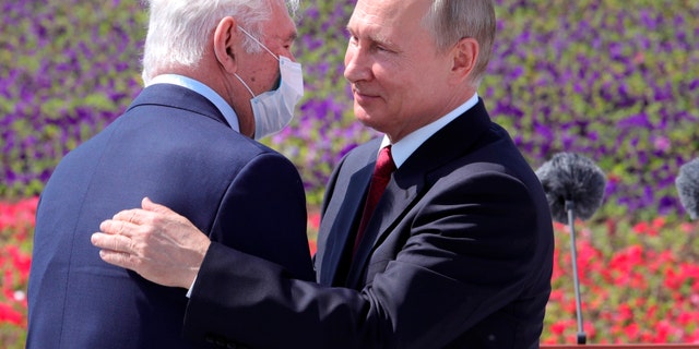 Russian President Vladimir Putin, right, congratulates the president of the Scientific Research Institute for Emergency Children's Surgery and Traumatology Leonid Roshal during a ceremony of handing Gold Stars medals to heroes of labor marking the Day of Russia holiday in Moscow, Russia, on Friday. (AP/ Sputnik/Kremlin Pool Photo)