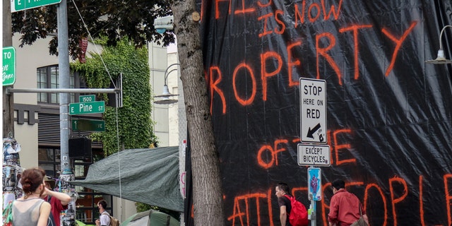 The seemingly abandoned East Precinct station of the Seattle Police Department is covered in a tarp declaring it 'property of the Seattle people'. Protesters declared a Cop Free Zone following days of demonstrations in response to the police-involved death of George Floyd in Minneapolis.