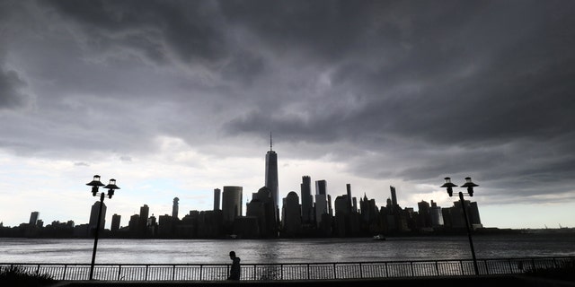 A rainstorm passes over lower Manhattan and One World Trade Center in New York City on May 11, 2020, as seen from Jersey City, New Jersey.
