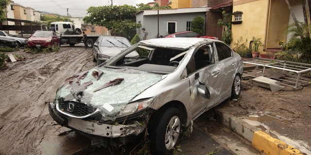 Vehicles stand damaged by the Acelhuate River after a flash flood at a neighborhood in San Salvador, El Salvador, Sunday, May 31, 2020.