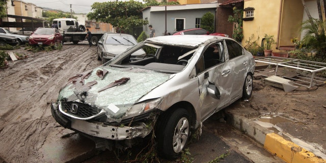 Vehicles stand damaged by the Acelhuate River after a flash flood at a neighborhood in San Salvador, El Salvador, Sunday, May 31, 2020.