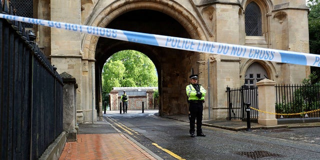 Police stand guard at the Abbey gateway of Forbury Gardens park in Reading town center Sunday following Saturday's stabbing attack in the gardens. (Jonathan Brady/PA via AP)