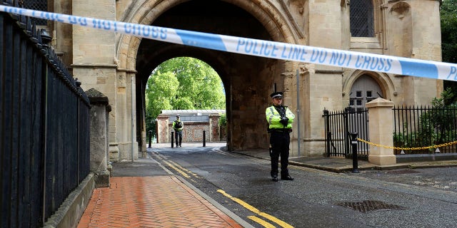Police stand guard at the Abbey gateway of Forbury Gardens park in Reading town center Sunday following Saturday's stabbing attack in the gardens. (Jonathan Brady/PA via AP)
