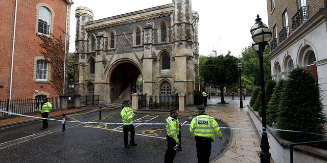 Police patrol the Abbey gateway of Forbury Gardens park in Reading town centre on Sunday following Saturday's stabbing attack in the gardens. (Jonathan Brady/PA via AP)