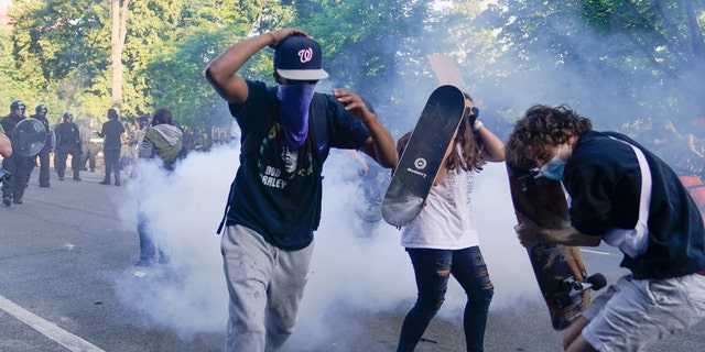 Demonstrators, who had gathered to protest the death of George Floyd, begin to run from tear gas used by police to clear the street near the White House in Washington, Monday, June 1, 2020. (Associated Press)