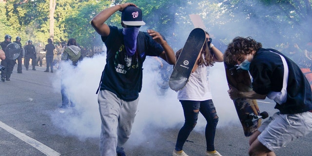 Demonstrators, who had gathered to protest the death of George Floyd, begin to run from tear gas used by police to clear the street near the White House in Washington, Monday, June 1, 2020. (Associated Press)