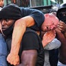 Protester Patrick Hutchinson carries an injured counter-protester to safety, near the Waterloo station during a Black Lives Matter protest in London, June 13, 2020. 