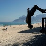 A young man somersaults on Arpoador Beach, amid the new coronavirus pandemic in Rio de Janeiro, Brazil,  June 20, 2020. 