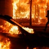 A protester runs past burning cars and buildings on Chicago Avenue in St. Paul, Minnesota, May 30, 2020. 