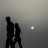 Police officers wearing masks walk at dusk under a cloud of Sahara dust hanging in the air in Havana Cuba, June 24, 2020. 
