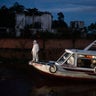 A health worker stands on a boat carrying COVID-19 patient Jose da Conceição as he waits for an ambulance to transfer him to a hospital after arriving in the port of Manacapuru, Amazonas state, Brazil, June 1, 2020. 