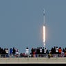 Spectators watch from a bridge in Titusville as SpaceX Falcon 9 lifts off with NASA astronauts Doug Hurley and Bob Behnken in the Dragon crew capsule from the Kennedy Space Center at Cape Canaveral, Florida, May 30, 2020.