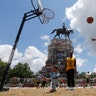 Isaiah Bowen takes a shot as his dad, Garth Bowen, looks on at a basketball hoop in front of the statue of Confederate General Robert E. Lee on Monument Avenue in Richmond, Virginia, June 21, 2020.