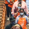 Mourners in Home Depot aprons waiting to view the casket.